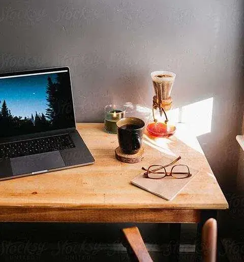 Laptop on wooden table in a room.